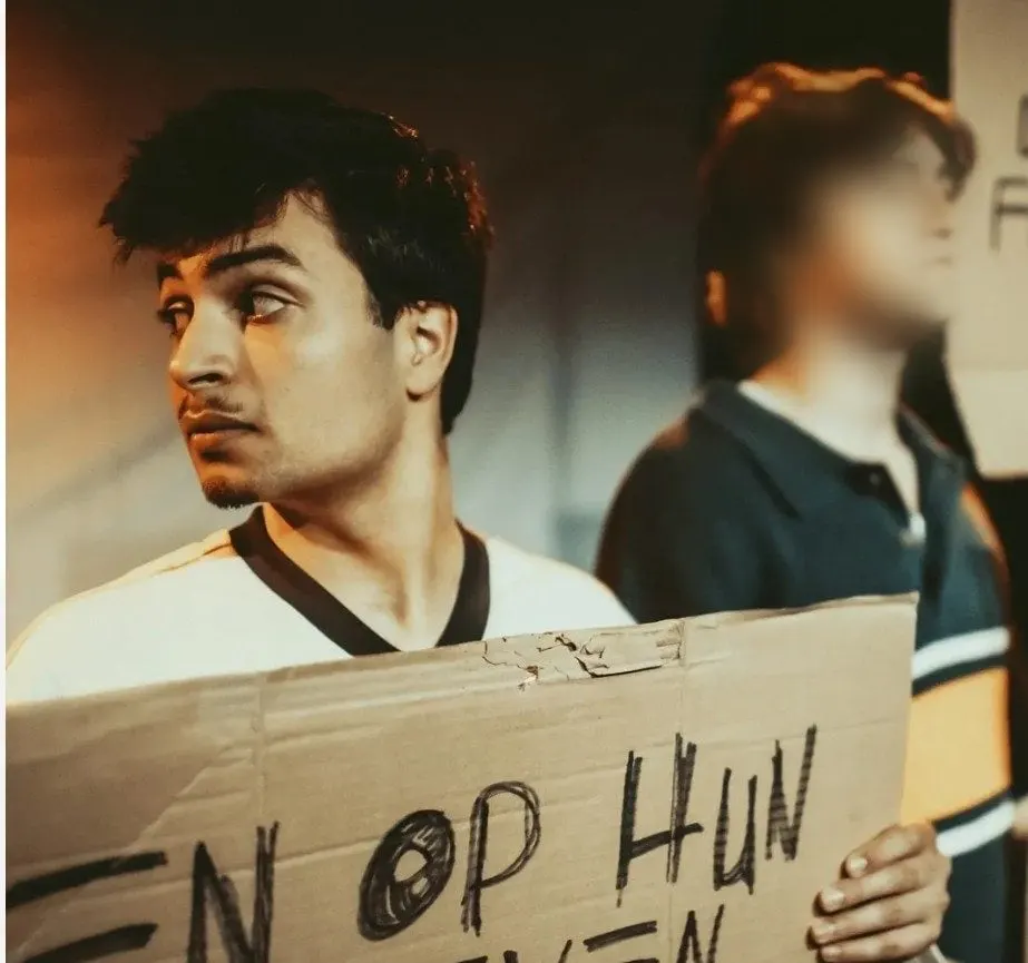 Rafael met een kartonnen protestbord in BANG BANG