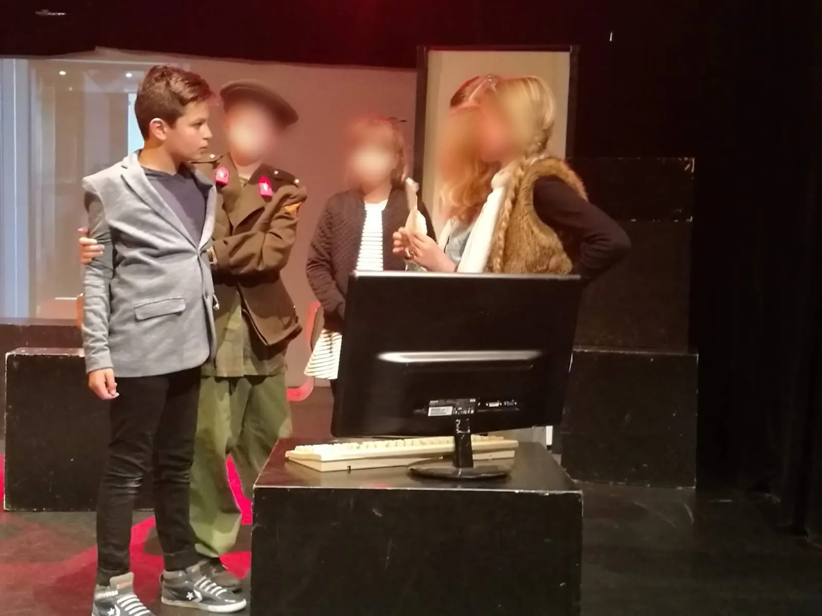 Rafael als kind in een grijs colbert op het toneel bij Kindertheater Cultuurkust