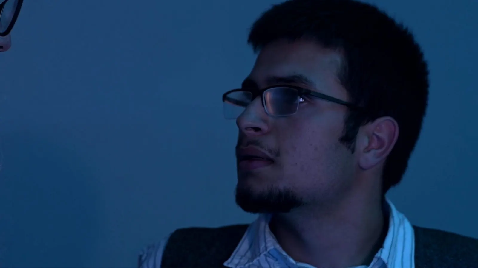 Rafael als Ludwig met bril in blauw licht, kijkt naar links