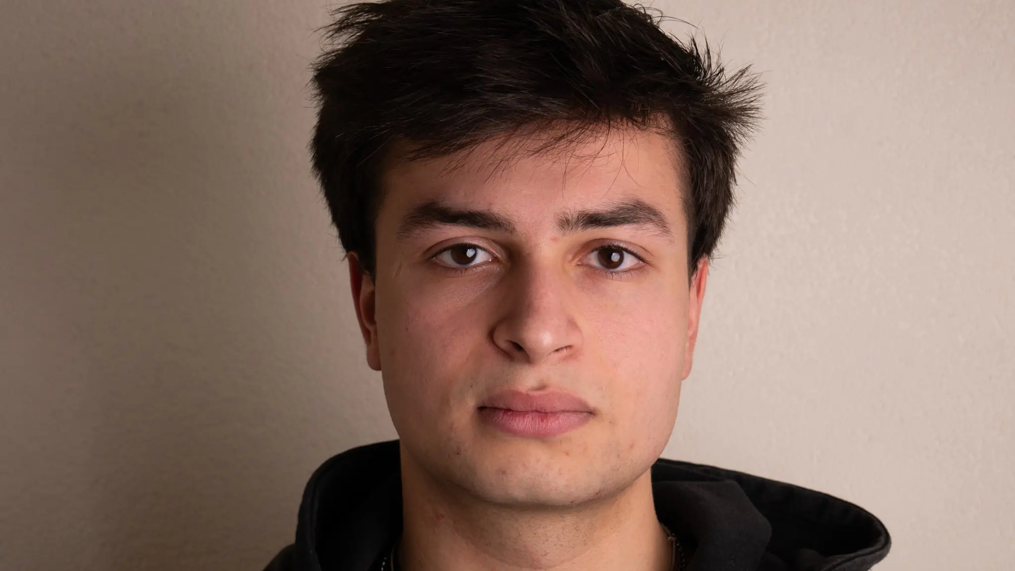 Headshot van Rafael in zwarte hoodie, neutraal