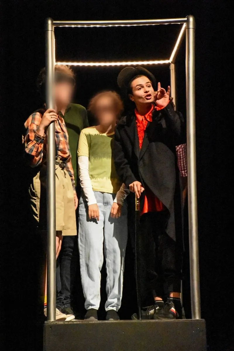 Rafael als Willy Wonka in kostuum met hoge hoed, met medespelers